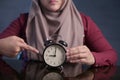 Muslim Woman Holding Clock Pointing at Nine O& x27;Clock, Lateness Concept