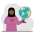 A muslim woman holds a globe in his hand and points his finger at it. The concept of education, teacher, world conquest
