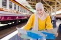 Muslim woman is looking at maps to plan their travel plans