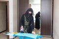 A Muslim woman national clothes doing household chores ironing