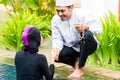 Muslim woman in pool greeting her husband Royalty Free Stock Photo