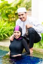 Muslim woman in pool greeting her husband Royalty Free Stock Photo