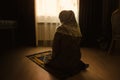 Muslim woman praying for Allah muslim god at room near window. H Royalty Free Stock Photo