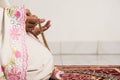 Muslim woman praying close up image of hands as she holds prayer beads,tasbih