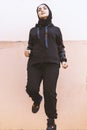 Muslim woman running. Middle-eastern woman in hijab training outdoors. Doing physical exercises on fresh air. Muslim female