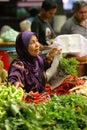 Muslim woman selling fresh vegetables at market in Malaysia