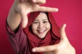 Muslim woman smiling at camera while framing her face with hands Royalty Free Stock Photo