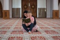 Muslim woman and son reading Koran, muslim family