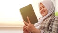 Muslim woman spending her time by reading favourite book, smiling happily