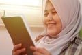 Muslim woman spending her time by reading favourite book, smiling happily