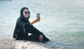 Muslim woman taking selfie on the beach Royalty Free Stock Photo