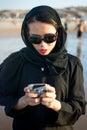 Muslim woman texting on the beach Royalty Free Stock Photo
