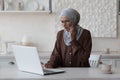 Muslim woman toothache at home, business woman in hijab working remotely from home, sitting in the kitchen using a