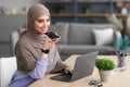 Muslim woman using voice search assistant on smart phone