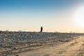 A Muslim woman walking on a dam at at beach towards to the sun in the morning in Dammam, Saudi Arabia Royalty Free Stock Photo
