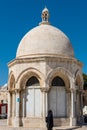 Muslim woman walking by The Dome of the Ascension at the square of the Golden Dome of the Rock, Qubbat al-Sakhra, on the Temple