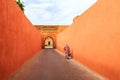 Muslim woman walking through a narrow street with gate in Marrakech Royalty Free Stock Photo