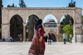 Muslim woman walking out of the square of the Golden Dome of the Rock