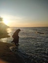 A muslim woman wearig burka on the beach during sunset Royalty Free Stock Photo