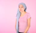 Muslim woman wearing a hijab with a ribbon on her chest shows prevention of breast cancer. On a pink backdrop, breast cancer