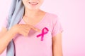 Muslim woman wearing a hijab with a ribbon on her chest shows prevention of breast cancer. On a pink backdrop, breast cancer