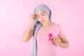 Muslim woman wearing a hijab with a ribbon on her chest shows prevention of breast cancer. On a pink backdrop, breast cancer