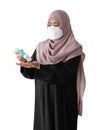 Muslim woman wearing a surgical mask washing hands with alcohol gel on white background. Covid-19 coronavirus concept Royalty Free Stock Photo