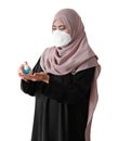 Muslim woman wearing a surgical mask washing hands with alcohol spray on white background. Covid-19 coronavirus concept Royalty Free Stock Photo