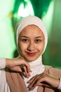 a Muslim woman in a white headscarf and white clothes poses with her hands without the slightest makeup on her face and smiles Royalty Free Stock Photo