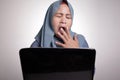 Muslim Woman Working on Laptop, Tired Sleepy Expression, Exhausted Overworked Concept Royalty Free Stock Photo