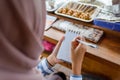 muslim woman write customer's order on a small note