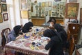 Muslim women artists in black headscarfs paint traditional Persian miniature in a workshop in Isfahan, Iran.