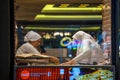 Muslim women in a bakery window preparing Turkish bread Istanbul Turkey night scene