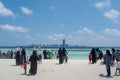 Muslim women and children walking towards ocean at the tropical beach