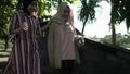 Muslim women in hijabs outdoors on sunny day with friend happy
