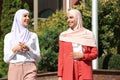 Muslim women in hijabs talking outdoors