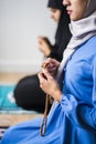 Muslim women using misbaha to keep track of counting in tasbih