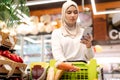 Muslim Young Woman Shopping Using Mobile Phone In Grocery Shop Royalty Free Stock Photo