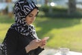 Muslim young woman typing message with her smartphone Royalty Free Stock Photo