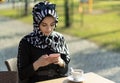 Muslim young woman typing message with her smartphone Royalty Free Stock Photo