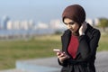 Muslim young woman typing message with her smartphone Royalty Free Stock Photo