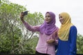 Muslimah having fun, spend time together and selfie at the city park