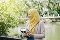 Muslimah woman standing and holding notebooks