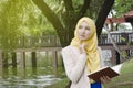 Muslimah woman standing and holding notebooks