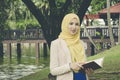 Muslimah woman standing and holding notebooks