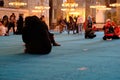 Muslims praying and tourist walking inside the mosque covered bottom of mosque with turquoise carpet Royalty Free Stock Photo