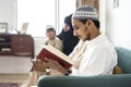 Muslims reading from the Quran at home