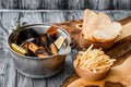 Mussel shells in a gray cauldron in tomato sauce, french fries and croutons on a gray background Royalty Free Stock Photo