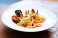 Pasta with mussels and arugula lying in white plate