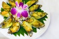 Mussels baked with cheese and garlic. Dish with seafood, fresh cabbage and orchid flower,Plate of delicious fresh baked mussels Royalty Free Stock Photo